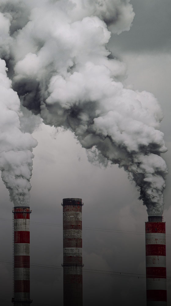 Three smokestacks billowing smoke